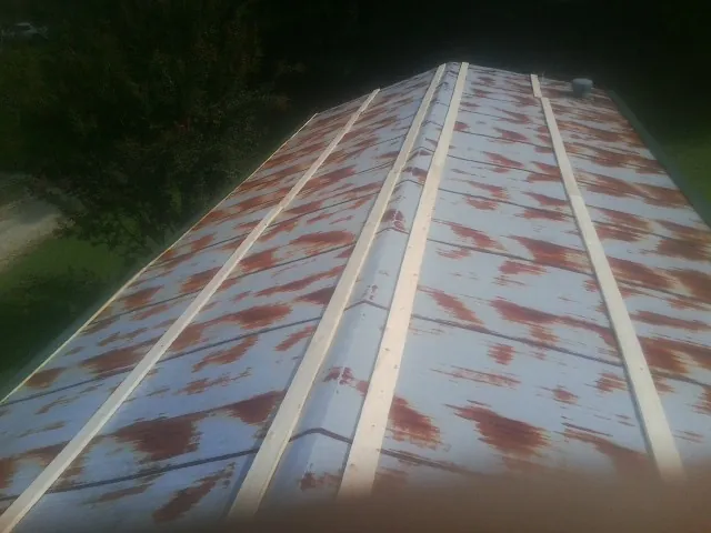Rusted metal roof panels with new wood purlins before replacement — Storm Damage Roof Repair in Carpenter by Roofing Brothers