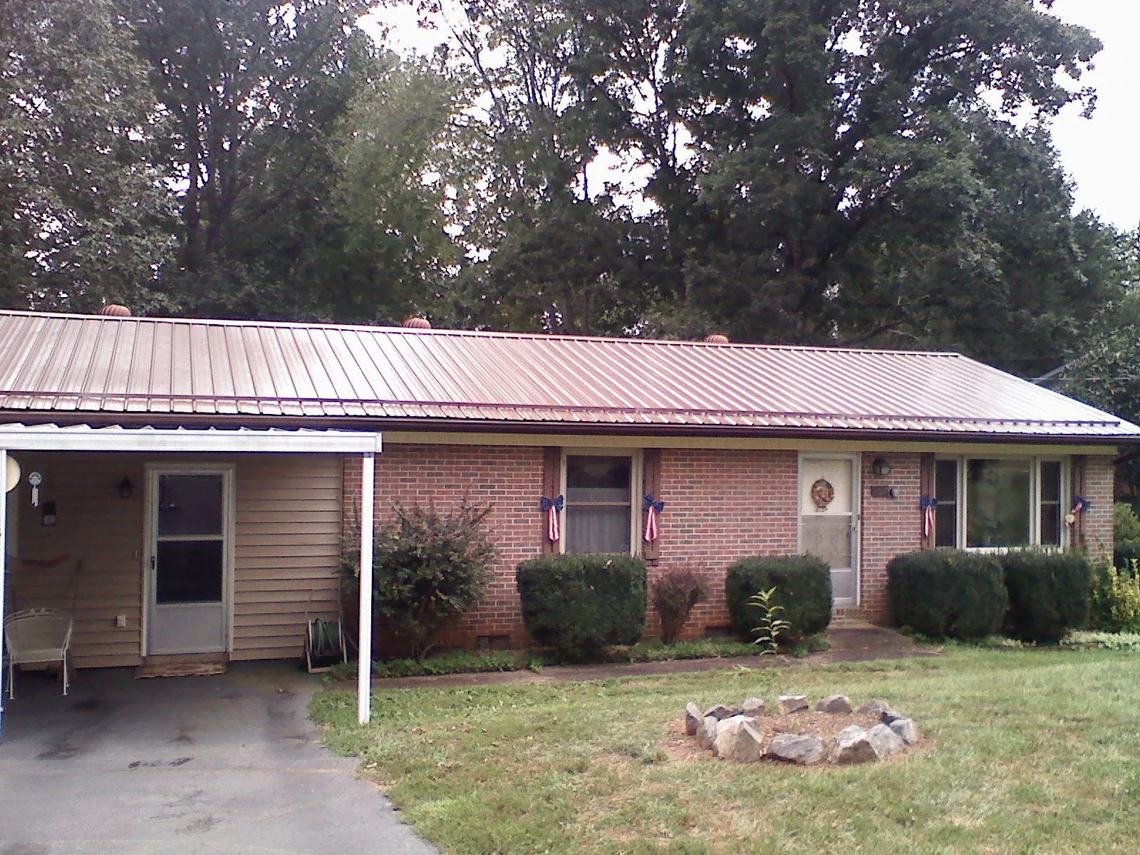 Bronze metal roof and carport on a brick ranch home — Roof Repair work by our crew in Carpenter