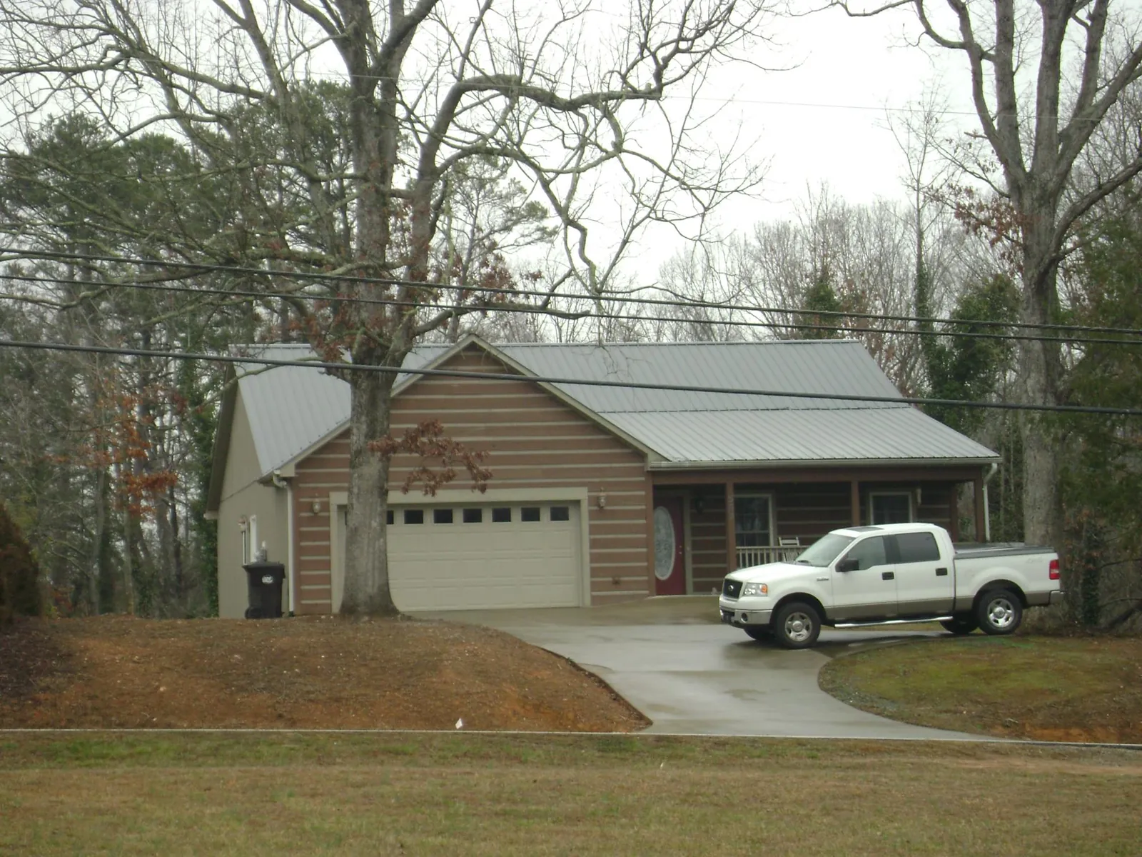 Gray metal roof on a log sided house with an attached two car garage in Carpenter