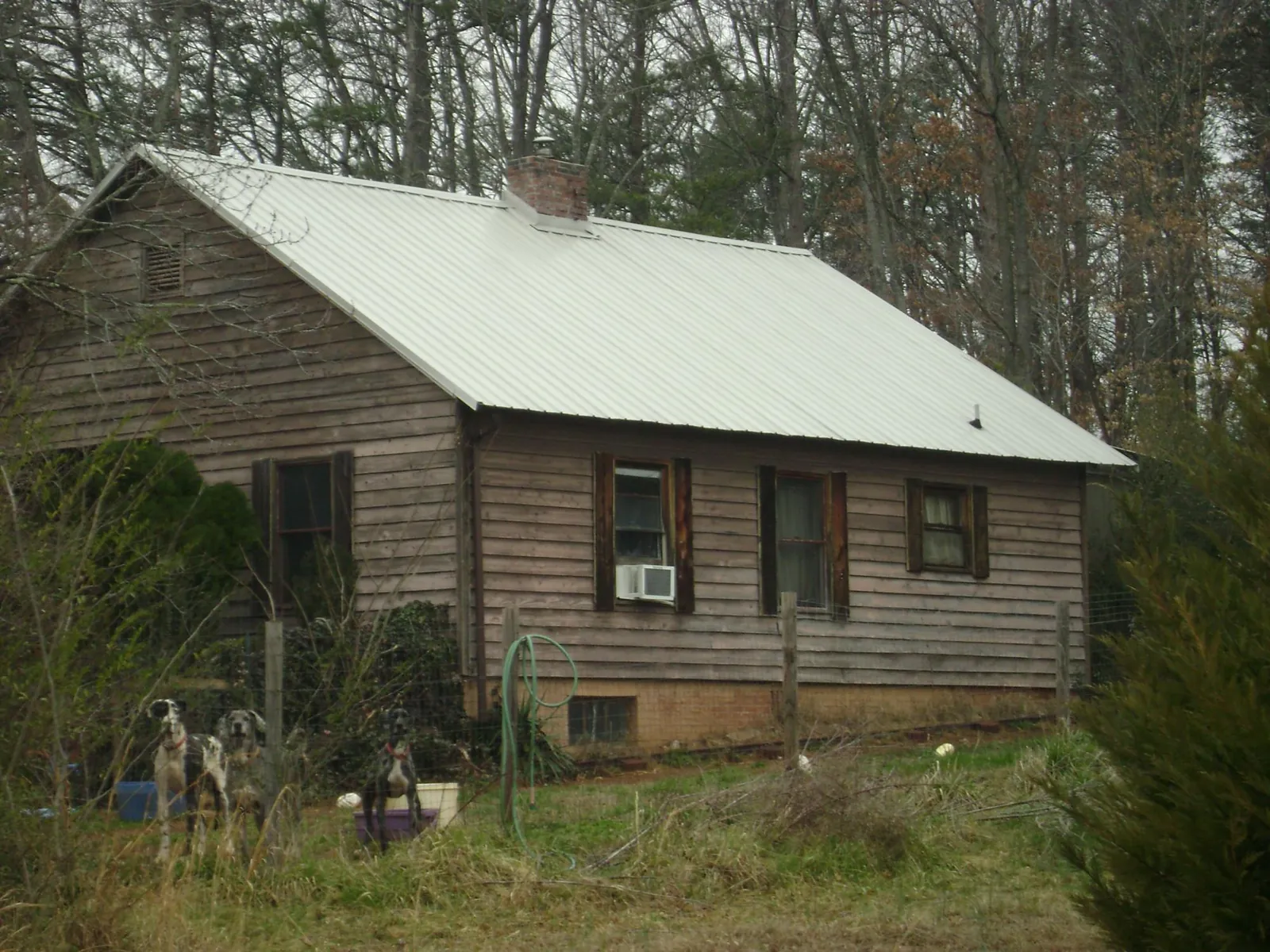 White metal roof on an old wood sided farmhouse, from a Metal Roof Installation job in Carpenter